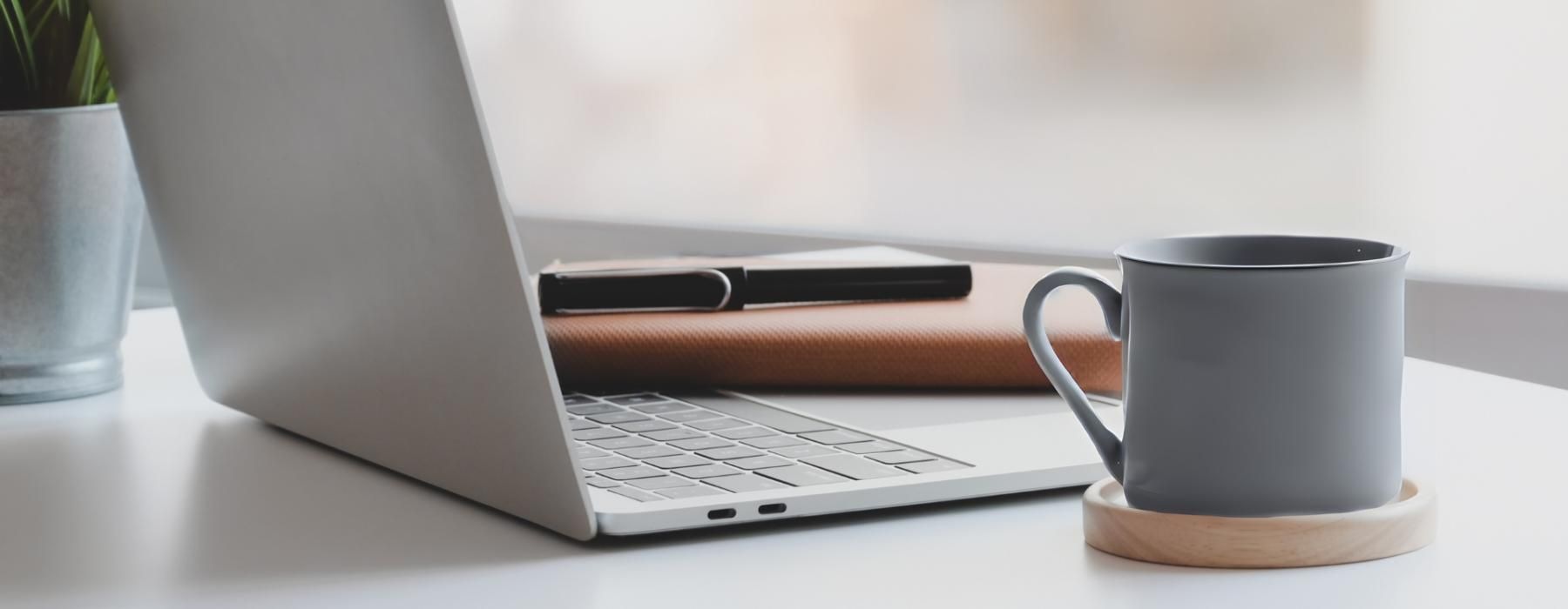 a laptop and a cup of coffee on a table